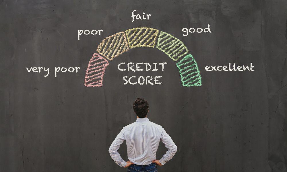 Man looking at credit scores written on a blackboard.