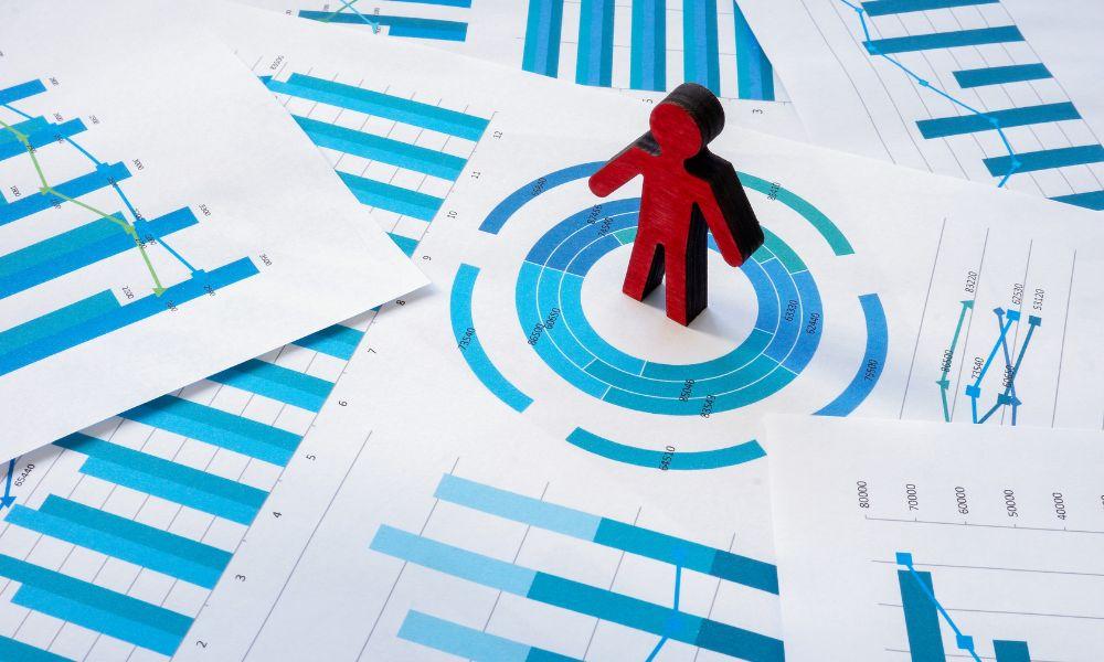 Wood figure standing on documents containing the strategy of a customer-centric approach.