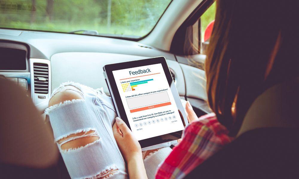 A woman sitting in a car and giving feedback on her customer experience.