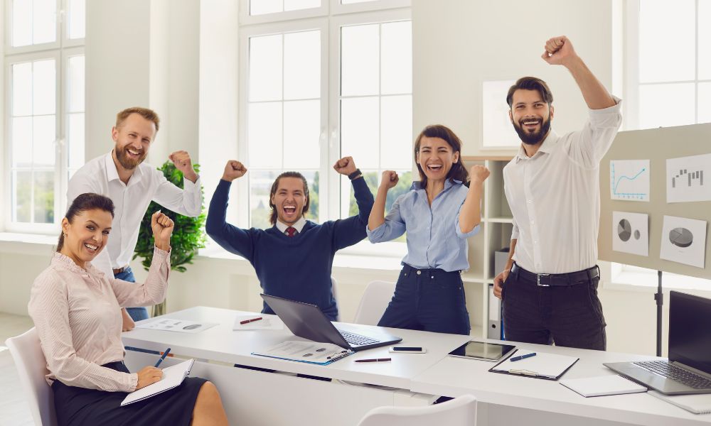 Happy sales team celebrating improved sales performance.