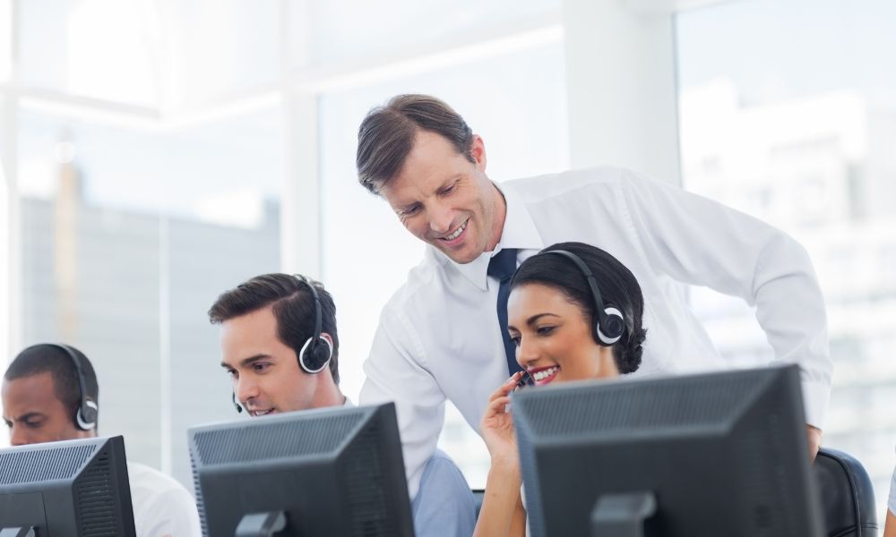 Call centre manager assisting one of the agents.