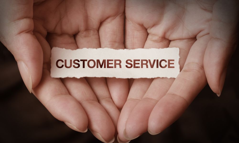 Hands holding a piece of paper with the words ‘customer service’ written on it.